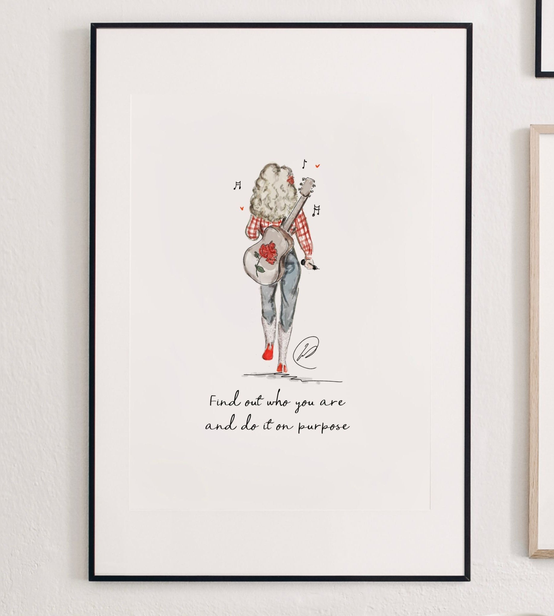 Find Out Who You Are print shown in a slim black frame with a white mount on a white wall, the watercolour illustration of a country singer walking away with her guitar sitting inside the mount window. Frame not included.